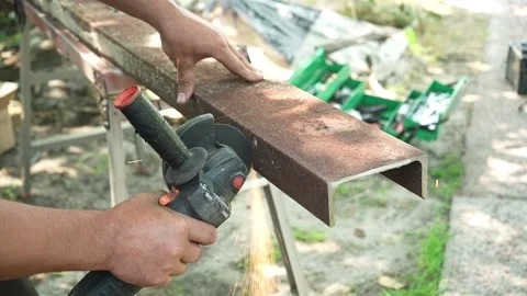 Worker cutting metal tube using an Angle Grinder. Bright sparks and flashes Stock Footage 258645760