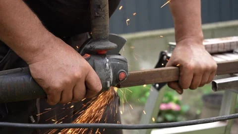Worker cutting metal tube using an Angle Grinder. Bright sparks and flashes Stock-Footage 258645805