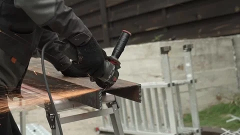 Worker cutting metal tube using an Angle Grinder. Bright sparks and flashes Stock-Footage 259027213