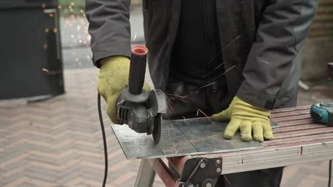 Worker cutting metal tube using an Angle Grinder. Bright sparks and flashes Stock Footage 259027260