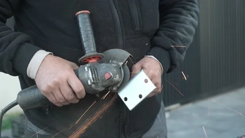 Worker cutting metal tube using an Angle Grinder. Bright sparks and flashes Stock Footage 259027261