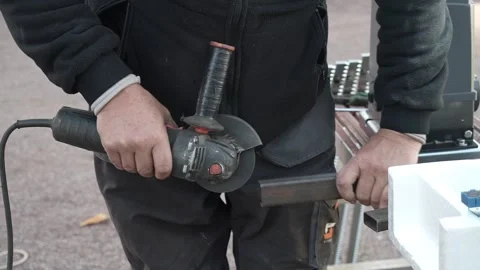 Worker cutting metal tube using an Angle Grinder. Bright sparks and flashes Stock Footage 259027265