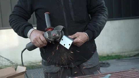 Worker cutting metal tube using an Angle Grinder. Bright sparks and flashes Stock Footage 259027266