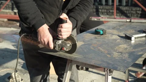 Worker cutting metal tube using an Angle Grinder. Bright sparks and flashes Stock Footage 259027310