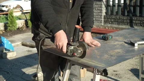 Worker cutting metal tube using an Angle Grinder. Bright sparks and flashes Stock Footage 259027312