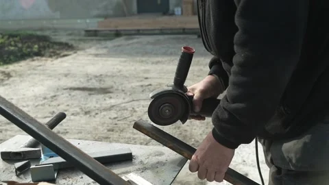 Worker cutting metal tube using an Angle Grinder. Bright sparks and flashes Stock Footage 259027334