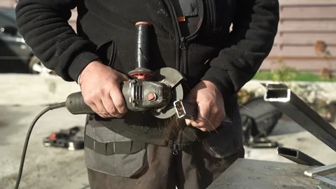 Worker cutting metal tube using an Angle Grinder. Bright sparks and flashes Stock Footage 259027356
