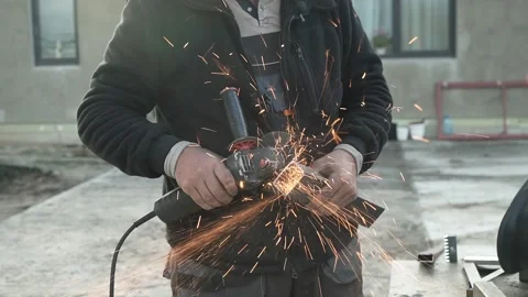 Worker cutting metal tube using an Angle Grinder. Bright sparks and flashes Stock Footage 259027378