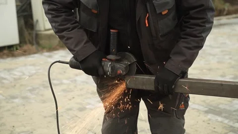 Worker cutting metal tube using an Angle Grinder. Bright sparks and flashes Stock Footage 259027379