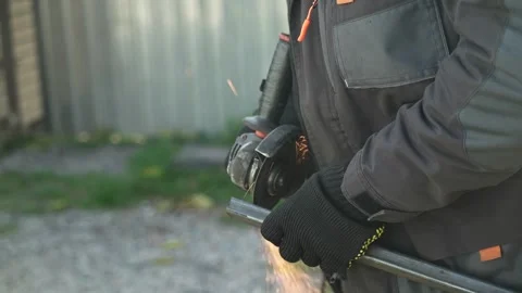 Worker cutting metal tube using an Angle Grinder. Bright sparks and flashes Video stock 259027389