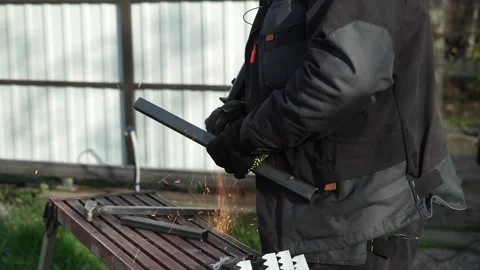Worker cutting metal tube using an Angle Grinder. Bright sparks and flashes Stock Footage 259027440
