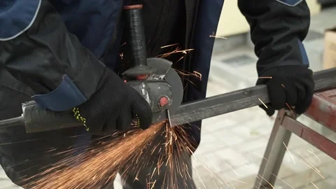 Worker cutting metal tube using an Angle Grinder. Bright sparks and flashes Stock Footage 259027502