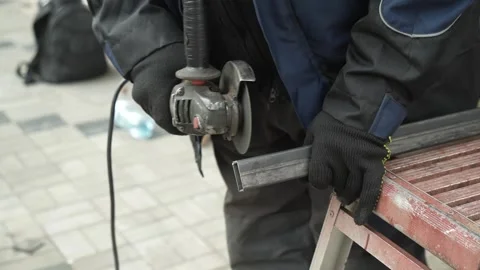Worker cutting metal tube using an Angle Grinder. Bright sparks and flashes Video stock 259027530