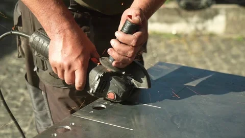 Worker cutting metal tube using an Angle Grinder. Bright sparks and flashes Stock Footage 259027632