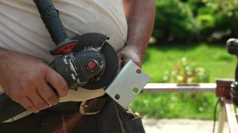 Worker cutting metal tube using an Angle Grinder. Bright sparks and flashes Stock Footage 259027644