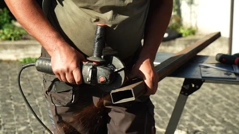 Worker cutting metal tube using an Angle Grinder. Bright sparks and flashes Stock-Footage 259027645