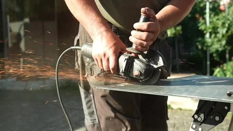 Worker cutting metal tube using an Angle Grinder. Bright sparks and flashes Stock Footage 259027685