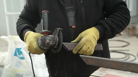 Worker cutting metal tube using an Angle Grinder. Bright sparks and flashes Stock Footage 259027697