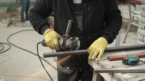 Worker cutting metal tube using an Angle Grinder. Bright sparks and flashes Stock Footage 259027725