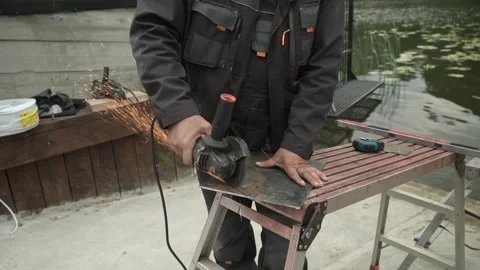Worker cutting metal tube using an Angle Grinder. Bright sparks and flashes Stock Footage 259027815