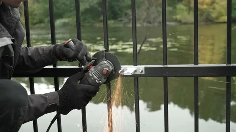 Worker cutting metal tube using an Angle Grinder. Bright sparks and flashes Stock Footage 259027822