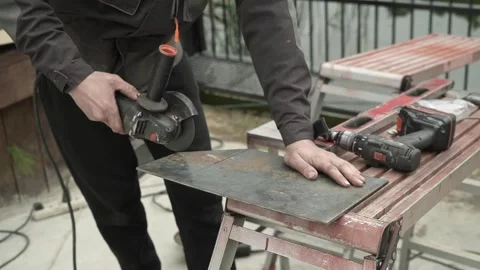 Worker cutting metal tube using an Angle Grinder. Bright sparks and flashes Stock Footage 259027825