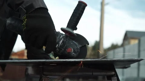 Worker cutting metal tube using an Angle Grinder. Bright sparks and flashes Stock Footage 261527997