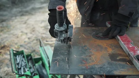 Worker cutting metal tube using an Angle Grinder. Bright sparks and flashes Stock Footage 261528038