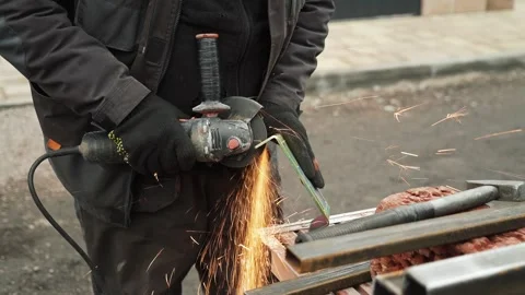 Worker cutting metal tube using an Angle Grinder. Bright sparks and flashes Video stock 261528307