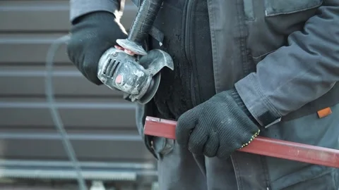 Worker cutting metal tube using an Angle Grinder. Bright sparks and flashes Stock Footage 261528328
