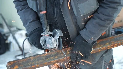Worker cutting metal tube using an Angle Grinder. Bright sparks and flashes Stock Footage 263186508