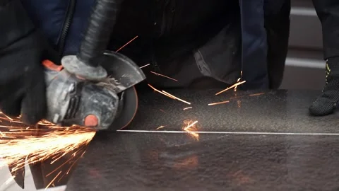Worker cutting metal tube using an Angle Grinder. Bright sparks and flashes Stock-Footage 263186542