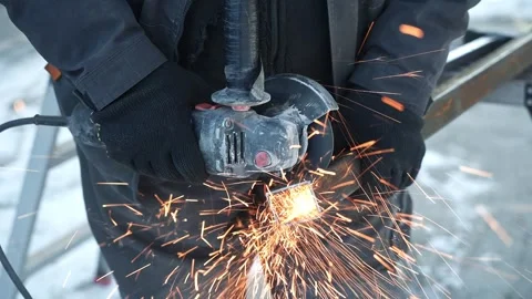 Worker cutting metal tube using an Angle Grinder. Bright sparks and flashes Stock Footage 263186555
