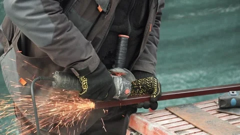 Worker cutting metal tube using an Angle Grinder. Bright sparks and flashes Stock-Footage 263186591