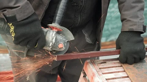 Worker cutting metal tube using an Angle Grinder. Bright sparks and flashes Stock Footage 263186597