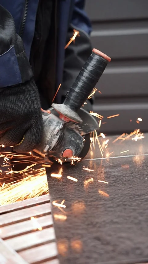 Worker cutting metal tube using an Angle Grinder. Bright sparks and flashes Stock Footage 263186613