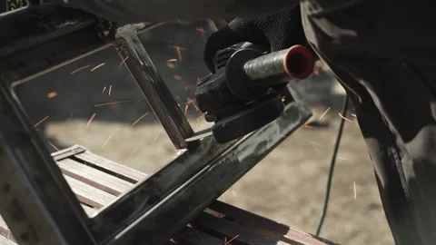 Worker cutting metal tube using an Angle Grinder. Bright sparks and flashes Stock Footage 266806003