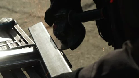 Worker cutting metal tube using an Angle Grinder. Bright sparks and flashes Stock Footage 266806095