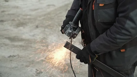 Worker cutting metal tube using an Angle Grinder. Bright sparks and flashes Stock Footage 266806479