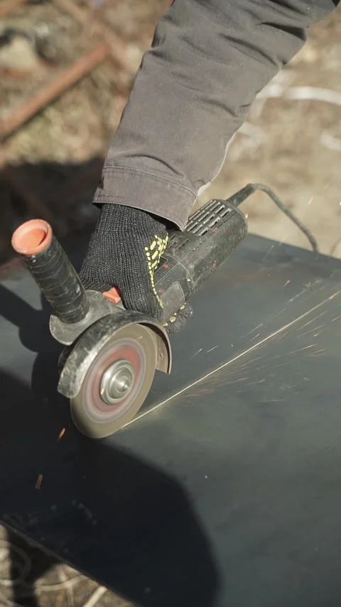 Worker cutting metal tube using an Angle Grinder. Bright sparks and flashes Stock Footage 266806597