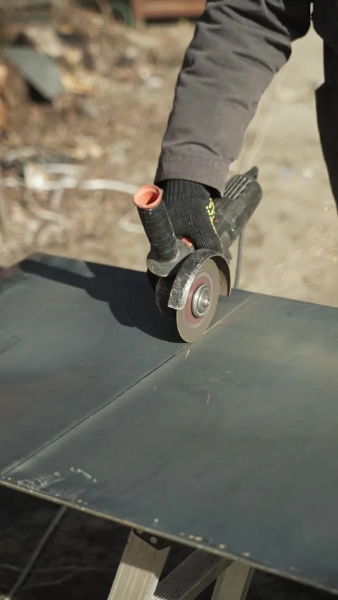 Worker cutting metal tube using an Angle Grinder. Bright sparks and flashes Stock Footage 266806619