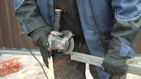 Worker cutting metal tube using an Angle Grinder Stock Footage 268794598