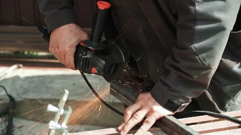 Worker cutting metal tube using an Angle Grinder. Bright sparks and flashes Stock Footage 274530460