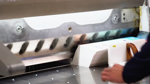 Worker cutting paper using paper cutting machine in a printing factory 動画素材 257028813