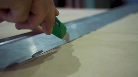 Worker Cutting Paper with a Utility Knife. Worker's hand cutting a paper templat Stock Footage 294263700
