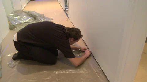 Worker cutting plastic covering the floor Stock Footage 60696805
