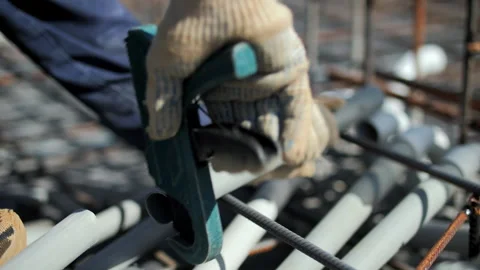 Worker cutting plastic pipe with clamp tool at construction site Stock Footage 316701769