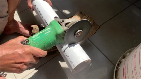A worker is cutting a PVC pipe with a disc cutting machine for DIY product needs 스톡 동영상 268956501