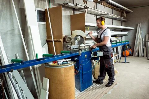 Worker cutting PVC profile with circular saw Stock Photos