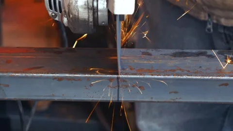 Worker cutting rectangular steel tube with an angle grinder tool creating sparks Vidéo 262802897